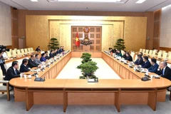 越南政府副总理、企业改革与发展指导委员会主任胡德福与老挝人民革命党中央企业改革委员会代表团举行工作会谈。图自《政府报》