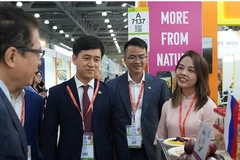 越南驻俄罗斯大使邓明魁参观越南企业的展位。图自越通社