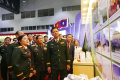 越南和老挝国防部领导参观2025年越南—老挝企业贸易对接与产品展销会上的展位。图自越通社
