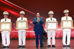 范明政总理向在工作中取得优异成绩的集体和个人授予“人民武装力量英雄”称号和一级军功勋章。图自越通社