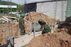 顺化市军事指挥部第6团战士们帮助人民建设新房。图自越通社