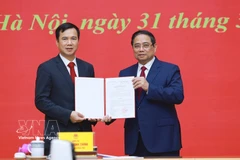 范明政总理向河内国家大学新任校长裴世维颁发任命决定。图自越通社
