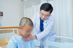 胡志明市医药大学附属医院神经外科主任张青情检查患者情况。图自越通社
