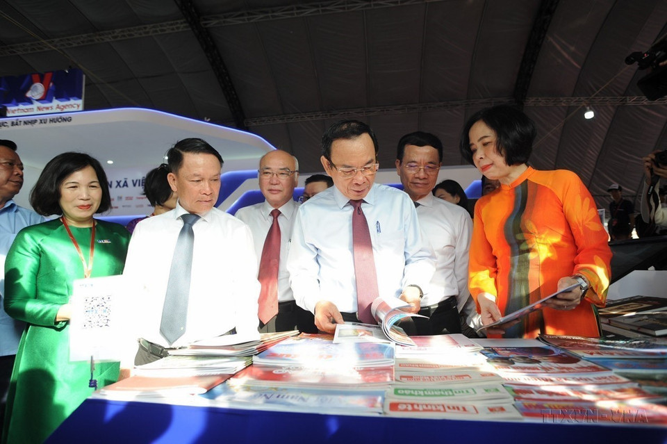 胡志明市市委书记阮文年及与会代表在2024年全国报刊展上参观越通社展位(2024年3月15日)。图自越通社