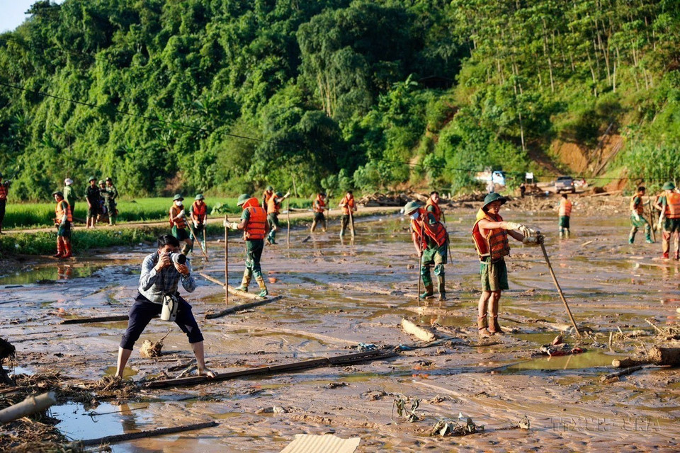 越通社图片编辑部记者杨江在老街省保安县福庆乡努村山体滑坡地区进行摄影报道(2024年9月12日)。图自越通社