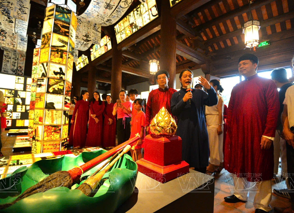 书法家向参观者介绍自己作品。图自越通社/越南画报