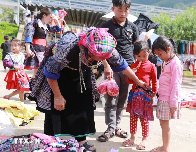 集市不仅是大人的场所，也为孩子们带来喜悦，因为来到这里，妈妈会给他们买新衣服。图自越通社