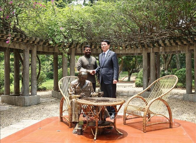 两位领导和"胡伯伯在主席府花园工作"铜像合影。图自越通社 vna-potal-chu-tich-nuoc-luong-cuong-va-tong-thong-sri-lanka-tham-khu-di-tich-chu-tich-ho-chi-minh-tai-phu-chu-tich-stand.jpg