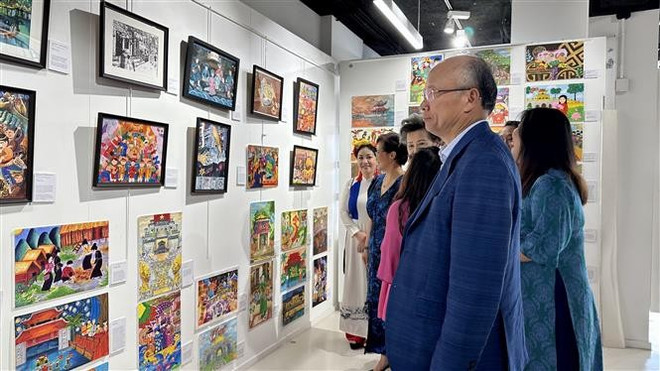 各位代表参观越南儿童们的画品。图自越通社 vna-potal-bonjour-vietnam-2025-noi-the-he-tre-nguoi-viet-ke-chuyen-van-hoa-dan-toc-8121862.jpg