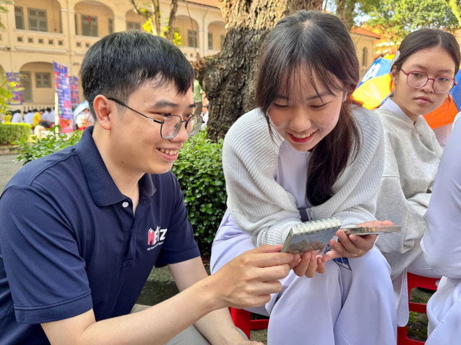 帮助学生下载和安装社交网络防诈骗应用程序。图自越通社 luadaoonline-2.jpg
