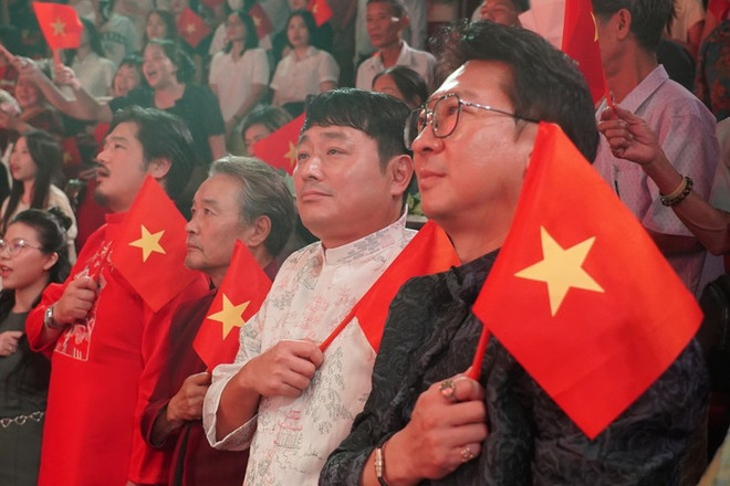 韩国制作团队身着奥黛,手持越南国旗观看演出。(越南话剧院供图) e-kip-san-xuat-tu-han-quoc-mac-ao-dai-cam-quoc-ky-viet-nam-xem-chuong-trinh-tu-phai-qua-thu-nhat-la-giam-doc-nghe-thuat-park-hyun-woo-thu-hai-la-dao-dien-cho-joon-hui-anh-nha-hat-kich-viet-nam.jpg