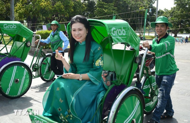 乘客可乘坐人力三轮车,安全便捷地游览顺化各处遗迹景点。图自越通社 nguoi-dan-trai-nghiem-mo-hinh-dich-vu-grab-xich-lo-tai-hue-anh-ttxvn.jpg