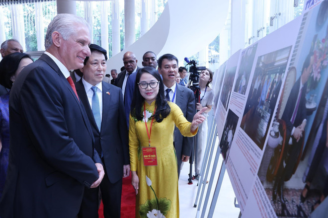 梁强和迪亚斯-卡内尔与两国代表、嘉宾一同参观有关两国关系的图片展。图自越通社 vna-potal-le-ky-niem-60-nam-thiet-lap-quan-he-ngoai-giao-viet-nam-cuba-8248794.jpg