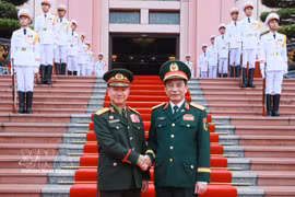 越共中央政治局委员、政府副总理、国防部长潘文江大将（右）在河内主持仪式，欢迎坎良·乌塔凯松大将一行。图自越通社