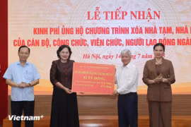 越南国家银行行长阮氏红向越南祖国阵线中央委员会递交银行职工捐赠的款项。图自越通社 