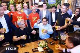2024年12月5日晚，越南政府总理范明政与NVIDIA公司创始人兼首席执行官黄仁勋一起享用河内街头美食。图自越通社