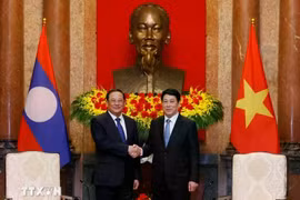 4月17日，越南国家主席梁强在河内会见了出席P4G峰会的老挝政府总理宋赛·西潘敦。图自越通社