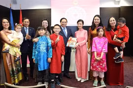 越南政府总理范明政和夫人向旅居爱沙尼亚的越南人赠送越南语书籍。图自越通社