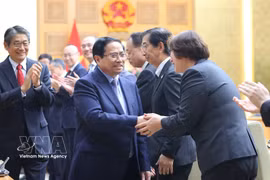 范明政总理与日方代表亲切握手。图自越通社