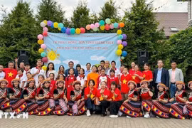 参与“越南语夏令营”活动的成员与各位代表合影。图自越通社