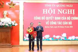 越共中央政治局委员、中央书记处书记、中央组织部部长黎明兴向越共中央委员、民族与宗教部常务副部长胡文年同志颁发任命书。图自越通社