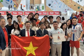 越南驻法国大使郑德海与参会的青年协会成员合影。图自越通社