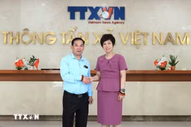 老挝人民革命党中央宣传部副部长、《人民报》（Pasaxon）总编辑万赛·塔汶炎与越通社社长武越庄合影。图自越通社