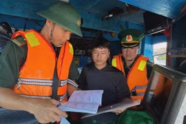 边防部队检查渔船的作业手续。图自越通社