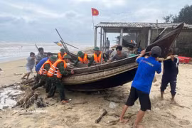 职能部门与渔民配合将船只靠岸避风。图自越通社