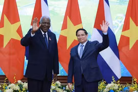 越南政府总理范明政与古巴全国人民政权代表大会主席埃斯特万·拉索。图自越通社