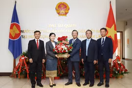 老挝财政部代表与越老合作委员会代表赠送献花，祝贺越南国庆80周年。图自越通社