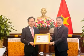 越南外交部常务副部长阮明宇向三星越南公司总经理崔裕浩授予“致力于越南外交事业”纪念章。图自越通社