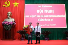 中央组织部代表向陈志光同志授予决定。图自越通社