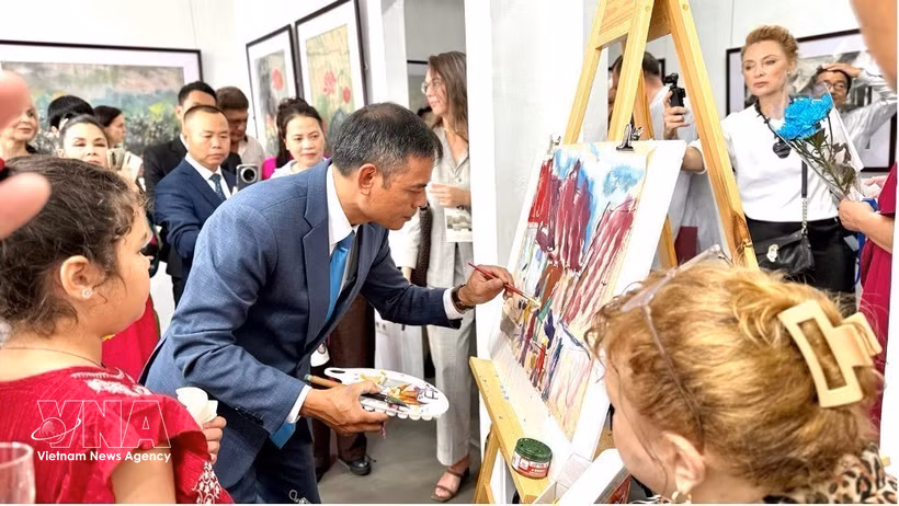 画家吴德煌在8月15日的展览现场演示在鼠皮纸上作画。图：越通社发