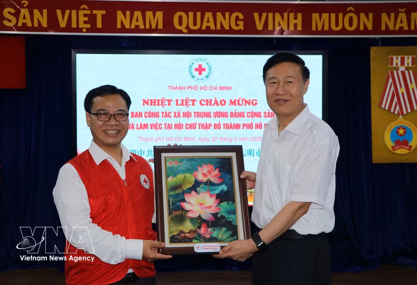 胡志明市红十字会主席阮明日向中共中央社会工作部副部长赵世堂赠送纪念品。图自越通社