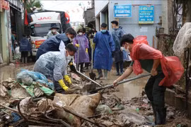  武装力量将村庄、居民区道路上的淤泥清除干净。图自越通社