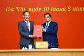 政府总理范明政向外交部新任代部长黎怀忠颁发任命书。图自越通社