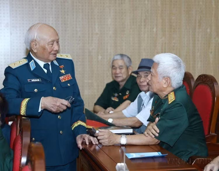 在庆祝越南防空导弹部队成立60周年座谈会上（1965年7月24日—2025年7月24日），“12个昼夜战役”中击落多架美军飞机的人民武装力量英雄、阮文撇中将与防空导弹部队老兵们亲切交流。图自越通社