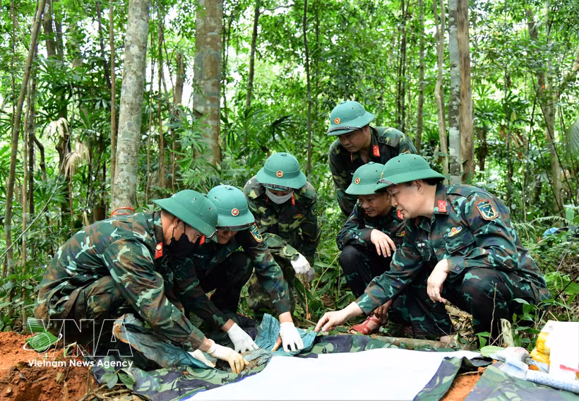 第337经济国防团烈士遗骸搜寻队工作人员在广治省向立乡Cựp Cuôi村Cây Lỗi溪山一带搜寻、归集烈士遗骸。图：越通社发