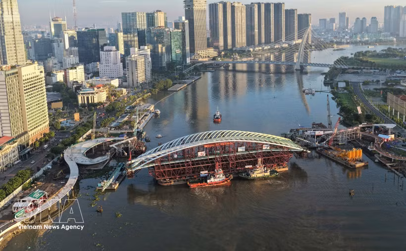 装载主跨结构的驳船就位于西贡河步行桥项目合龙位置全景图。图：越通社