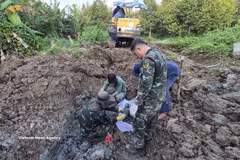 K91队在同塔省五协乡平和村榴莲园内搜寻并挖掘出多具烈士的遗骸。图片来源：越通社