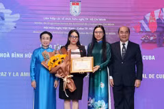 胡志明市友好组织联合会主席何清向古巴驻胡志明市总领事阿里亚德娜·费奥·拉布拉达颁授“致力于各民族和平友谊”的纪念章。图自越通社