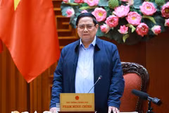 越南政府总理范明政在政府驻地就为洪涝灾后民众修建、修缮房屋计划"光中战役"实施情况，与广治省委常委会召开工作会议。图自越通社