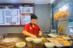 厨师正在为顾客准备鸡肉河粉。图自越通社