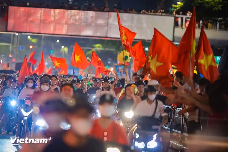 在越南国家足球队夺冠之夜，胡志明主席的画像与金星红旗出现在越南各条街道。图片来源：Vietnam+