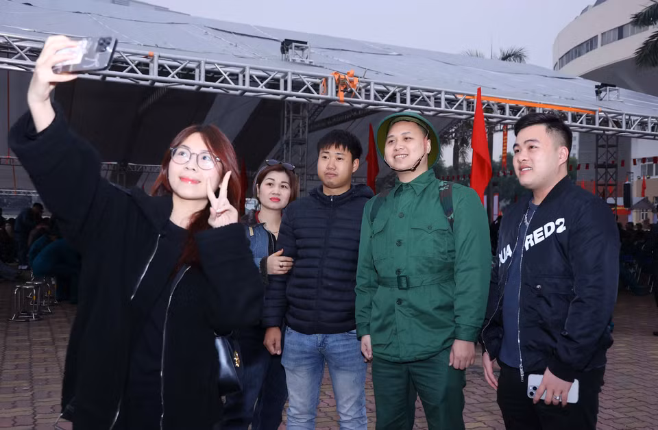 亲友在新兵交接仪式上与新兵合影留念。图自越通社