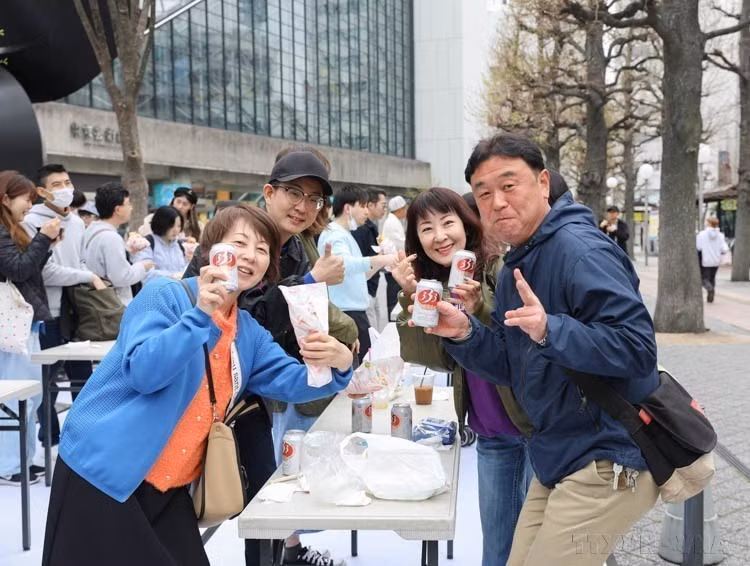 2024年4月6日，日本游客在池袋公园举行的越南节上愉快地品尝越南啤酒。图自越通社