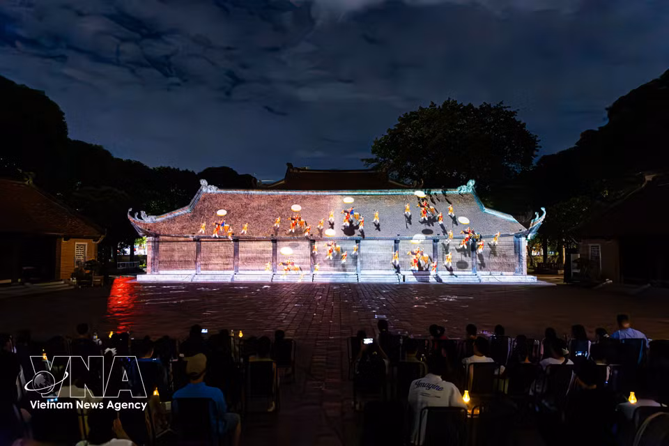 现代3D Mapping技术投射在文庙古朴建筑上，向众多观众再现越南儒学发展历程。图自越通社