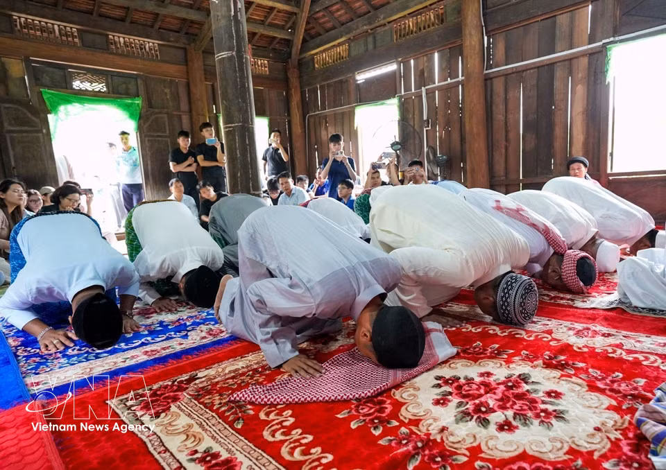 身着传统服饰的伊斯兰占族男子一同前往清真寺进行祈祷仪式。图自越通社