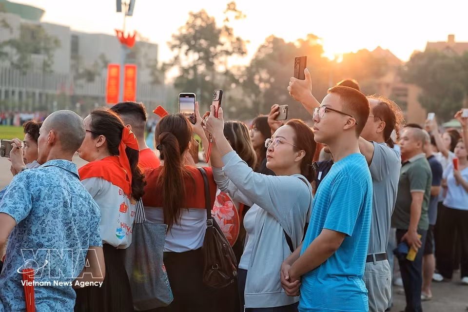 众多民众聚集在巴亭广场周围，将手机镜头对准仪式区域，记录国庆81周年纪念日的画面。图自越通社